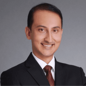 Arjun Sharma, investment advisor, smiles in a professional headshot.